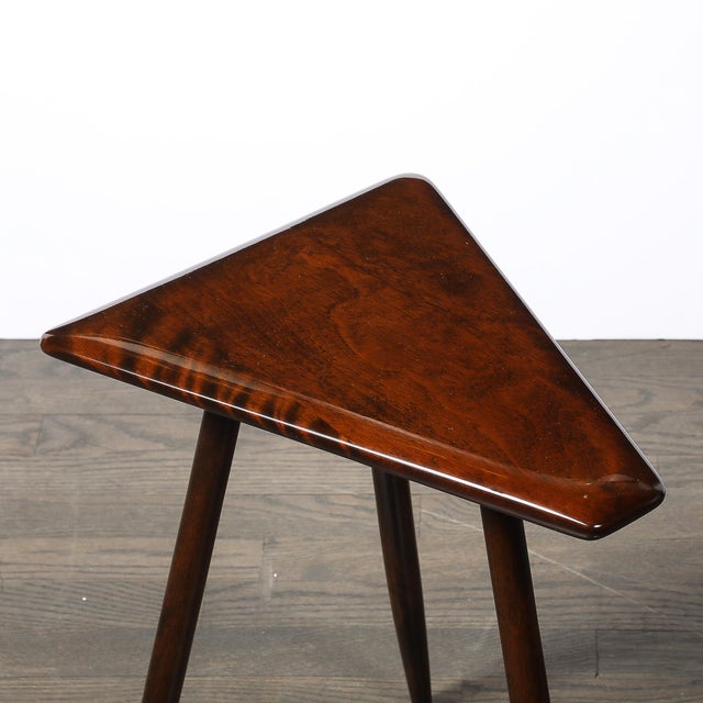 This Mid-Century Modernist triangular side table, crafted by Cushman and signed by the maker, is an elegant and...