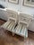 Two Bellman Chairs in white lacquered with gold gilding through-out chair. The seats are upholstered in S. Harris silk...