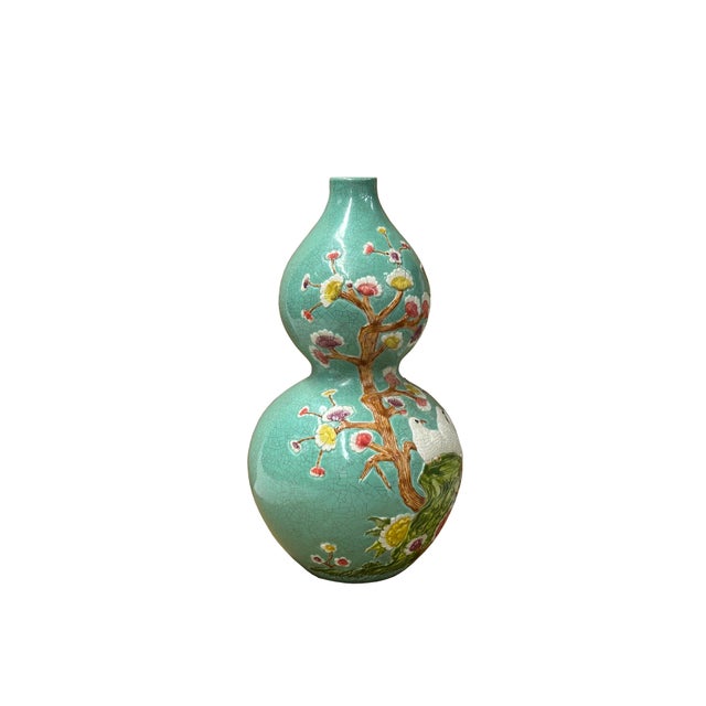 This striking Chinese porcelain vase, shaped like a double-gourd or hulu, features a beautiful, crackled celadon-green...