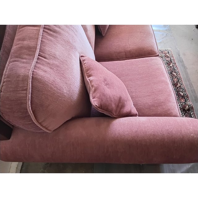 A charming vintage loveseat featuring dusty rose pink upholstery paired with an elaborately carved dark wood frame. The...