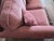 A charming vintage loveseat featuring dusty rose pink upholstery paired with an elaborately carved dark wood frame. The...