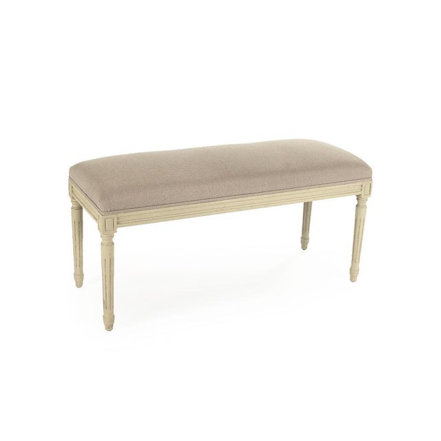 The Lille Bench from Zentique offers understated French elegance with a padded natural linen seat on a distressed cream-...