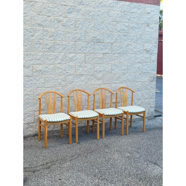 Set of four dining chairs, late 20th century. Light oak frames with rounded legs and arched crest rails. Vertical slat...