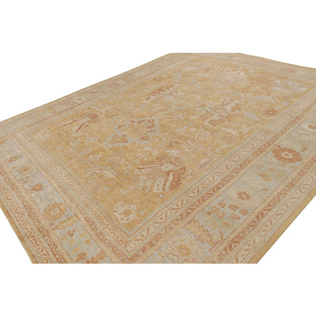 This 12x15 rug from the Modern Classics Collection features a gold field, blue and beige-brown borders underscore...