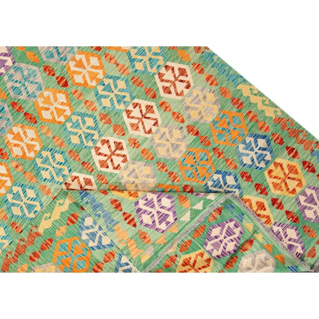 21st Century contemporary hand-woven Afghan Kilim with an allover geometric motif. Made with wool, measures 8' 2" x 11' 7"