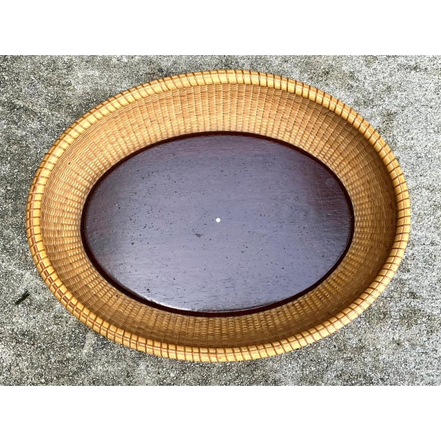 Inspired by the enduring tradition of Nantucket basketry, this vintage woven rattan basket combines timeless craftsmanship...