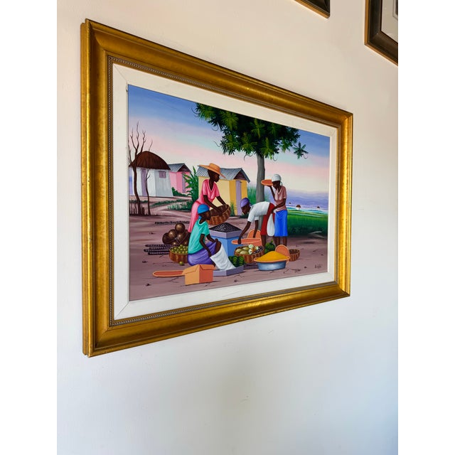 This vibrant vintage oil on canvas by Haitian artist E. Constant captures a lively village market scene against the serene...