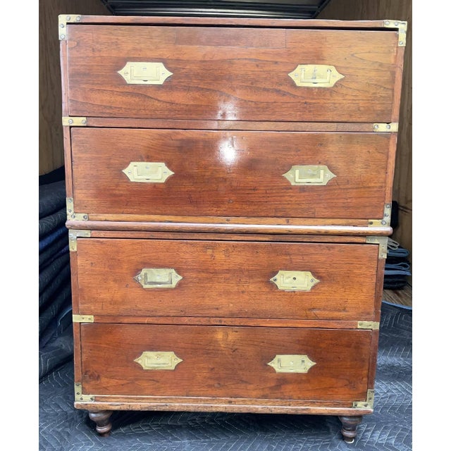 Two part campaign chest bureau with two drawers on each half. Inlaid brass handles and corners. Four bun feet. Nice...