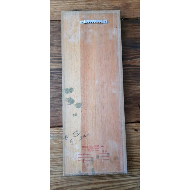This unique mid-century piece features cast metal brass insignias mounted on a wooden board. The plaque's sides are...