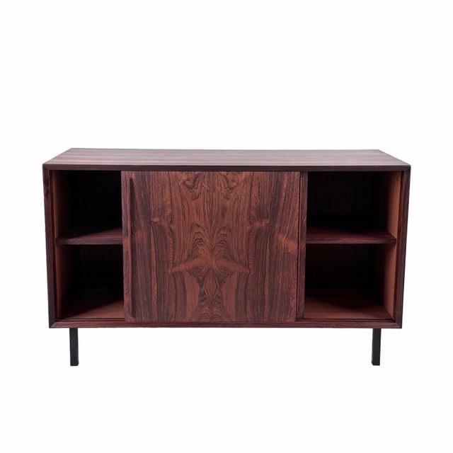The stunning rosewood grain detail enhances the rich wood patina of this vintage storage piece. Masterfully crafted in...