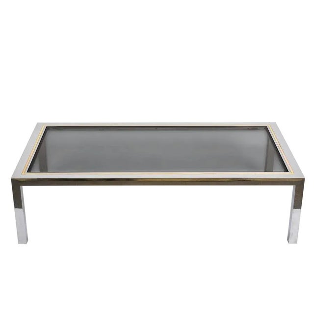 Large Mid-Century chromed steel structure coffee table with internal brass frame. The top is in smoked glass. This iconic...