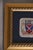 A beautifully framed embroidered patch featuring a ship crest flanked by seahorses on a navy linen mat, set in a gold...