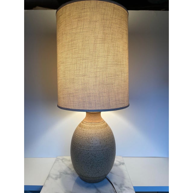 A beautifully crafted mix of texture and tone, this signed 1977 handmade ceramic and wood table lamp showcases the...