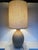 A beautifully crafted mix of texture and tone, this signed 1977 handmade ceramic and wood table lamp showcases the...