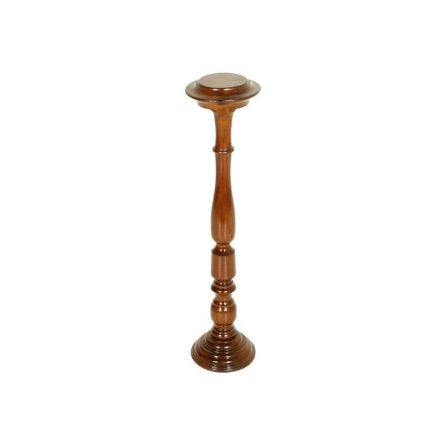 This Mid-Century Modern pedestal column in turned walnut has been polished and waxed.