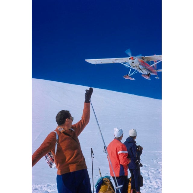Haute Route Flyby by Toni Frissell A ski plane flies over head a group of skiers partaking in the infamous “Haute Route",...