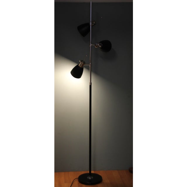 This floor lamp was made in France in the 1960s. It consists of three black lacquered shades as well as chrome-plated...