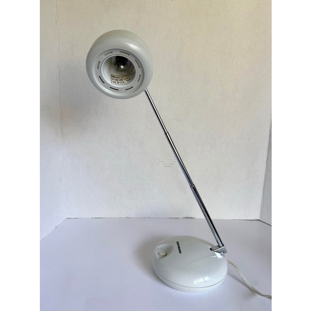 Here is a stylish 1990s Tensor task lamp featuring a classic eyeball shade, crisp white finish, and polished chrome...