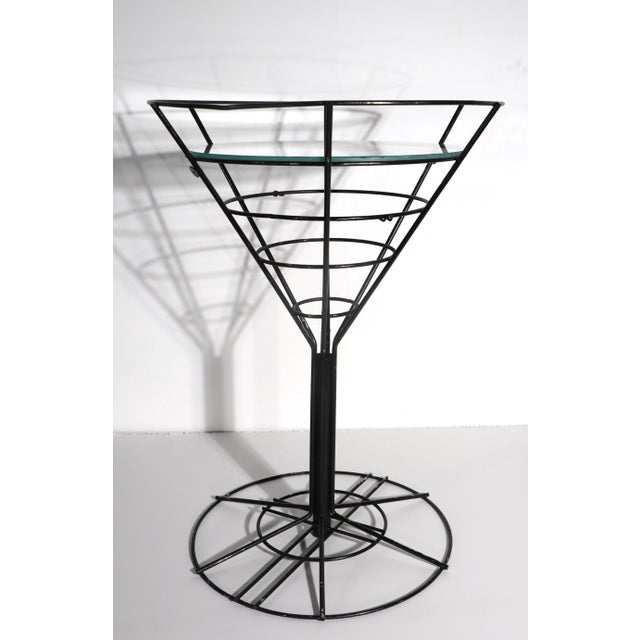 Fun side table in the form of a martini glass, having a wrought iron frame with a glass insert top. The table is in good...