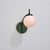 Italian wall sconce from the 1950s, defined by a curved black lacquered brass stem, spherical opaline glass diffuser and...