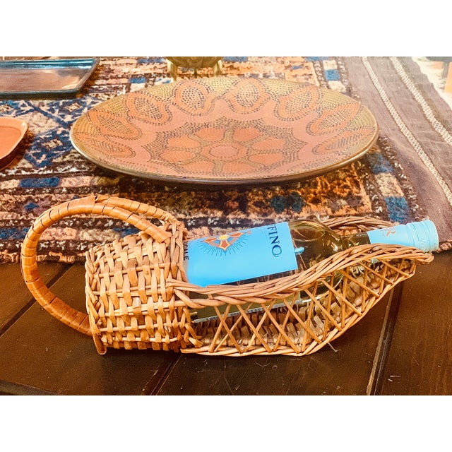 Vintage hand weaved natural wicker basket wine bottle caddy from the mid-century. The weaving is intricate and remarkably...
