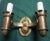 Three Arts & Crafts period double candle sconces of hammered brass in a rather Gothic style with much detail. The label...