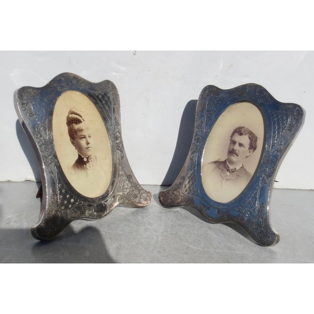 A pair of 2 silver-plated photo frames. Classic Beaux-Arts designs with oval windows, which still include the original...