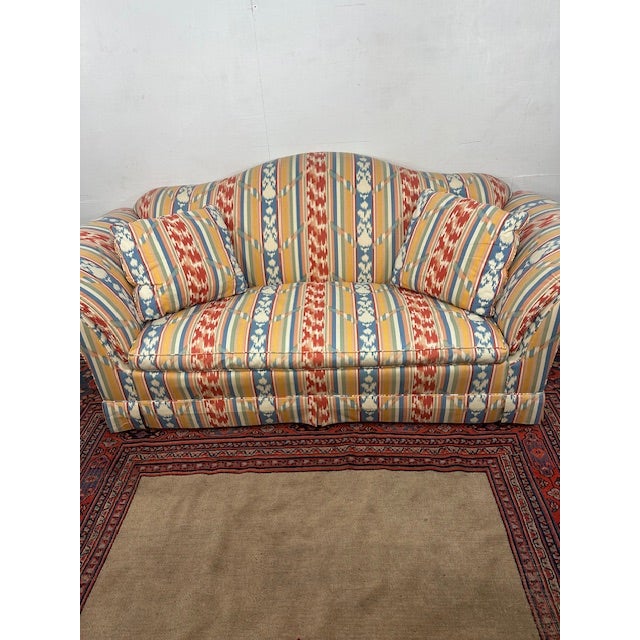 This vintage camel-back sofa by Baker Furniture is a statement piece that instantly elevates any room with its refined...