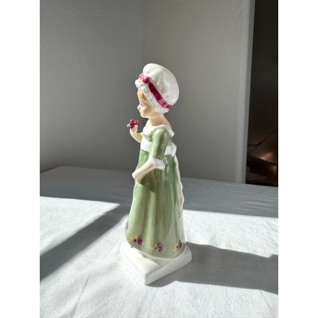 The Royal Doulton Figurine "Ruth" HN 2799 is a late-20th-century bone china figure depicting a young woman in a flowing...