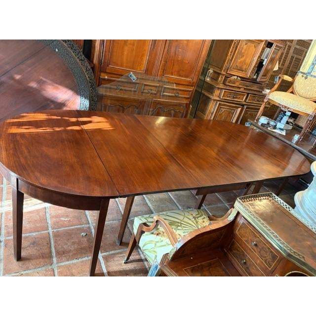 This pair of English D end tables with a mahogany dining table from circa 1840 is a stunning addition to any antique-...