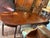 This pair of English D end tables with a mahogany dining table from circa 1840 is a stunning addition to any antique-...