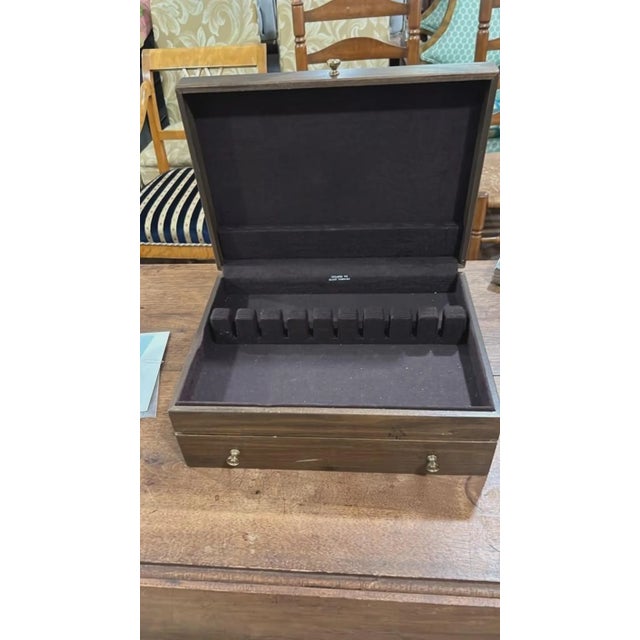 A classic vintage silver-plated flatware set with service for 12, housed in a dual-level dark wood anti-tarnish storage...