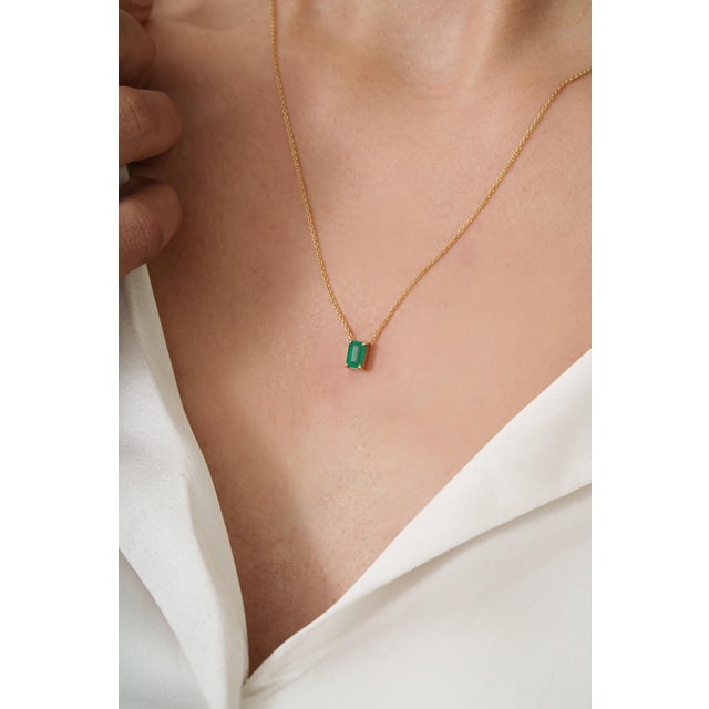 This pendant necklace is featuring a octagon-cut emerald set in 18K yellow gold. The measuring approximately 6 x 4 mm. The...