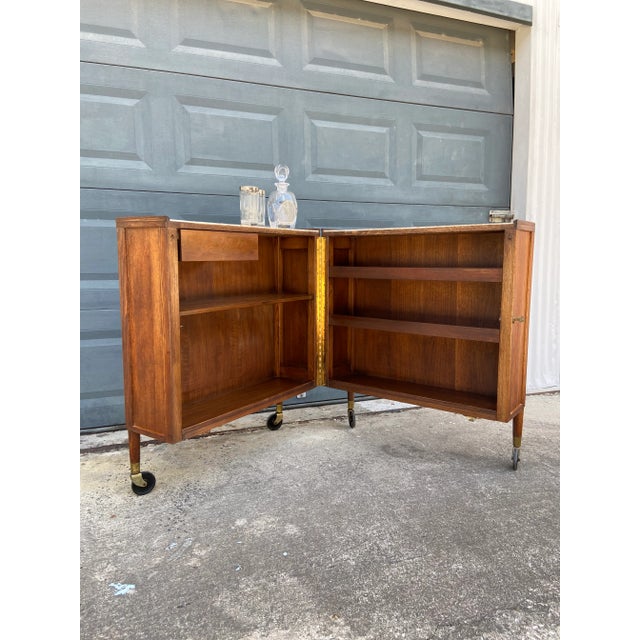 Designed by Henry P Glass for Saginaw Furniture. c.1950s This dry bar is amazing! A compact design with a walnut finish....