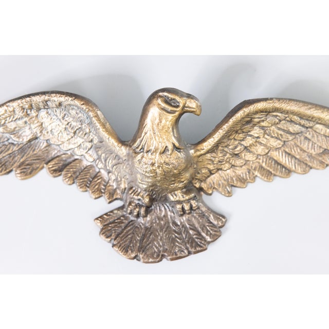 A fine vintage mid-century federal American brass eagle hanging wall plaque. This regal eagle is a large size and heavy...