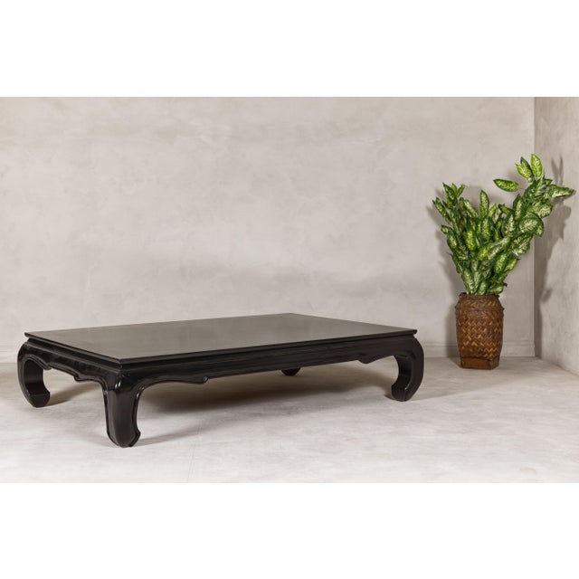 A vintage teak wood chow legs coffee table with custom black lacquer finish. This vintage teak wood coffee table,...