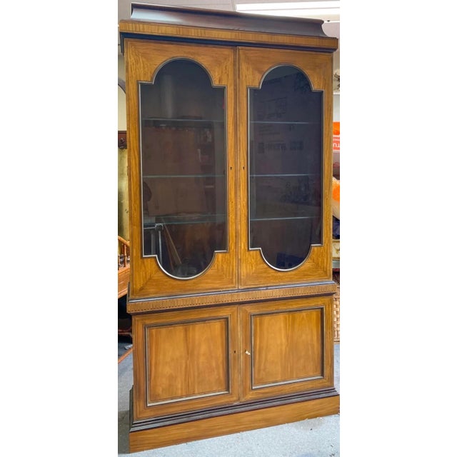 This is a good looking cabinet! This is a neo-classical style cabinet by Baker Furniture Company. The top portion is lit,...