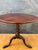 English Georgian style tripod table, early 20th century. The table features a round top supported by a turned pedestal...