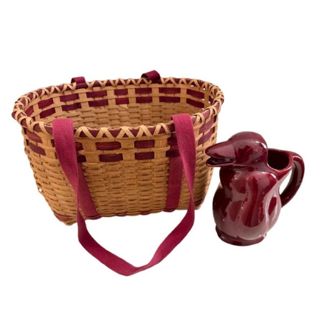 Vintage handwoven rectangular splint basket featuring natural tan wicker sides with burgundy accent reeds and a matching...