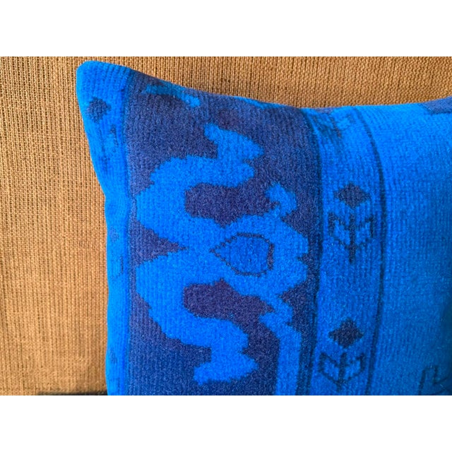 Electric blue and deep navy tones intertwine across authentic vintage wool fragments, forming distinct geometric registers...
