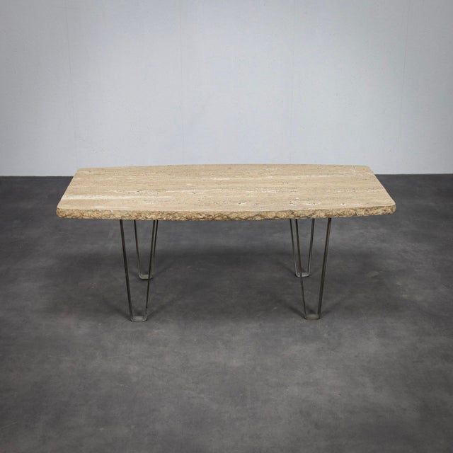 A timeless coffee table from 1970s italy, featuring a beautiful travertine stone top combined with slim metal legs. The...