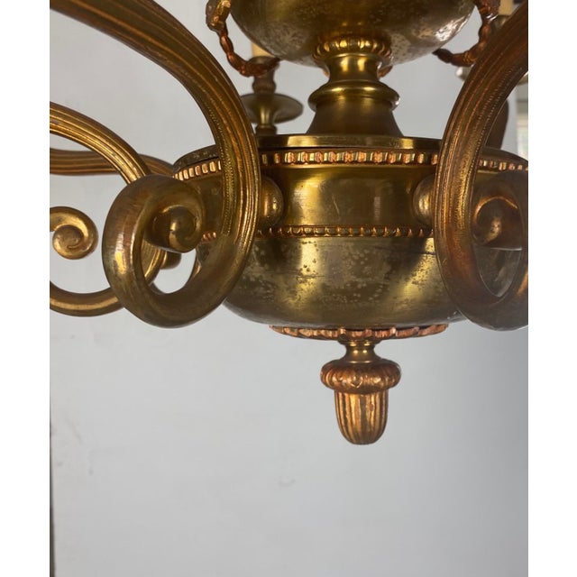 A Art Nouveau style brass 8 light chandelier. The chandelier is heavy and of fine quality. Wired for USA.