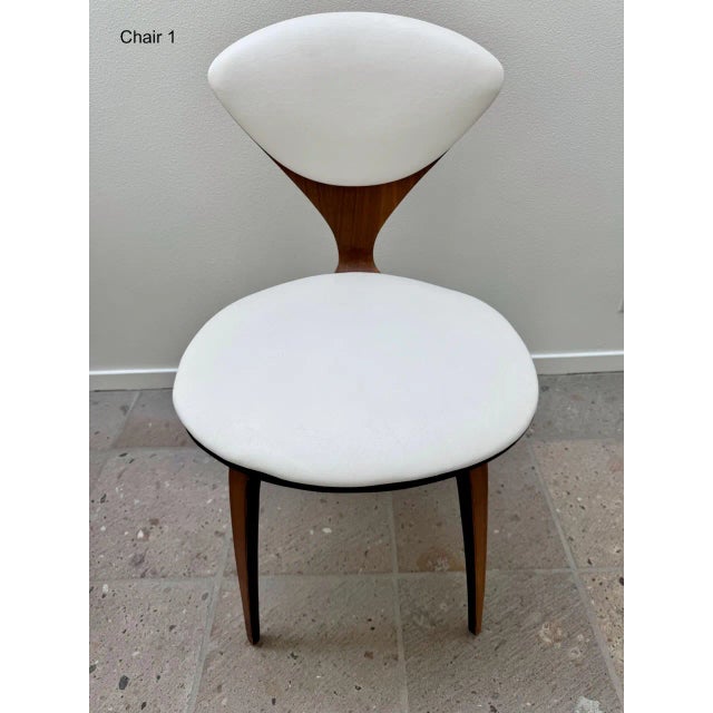 For sale is a set of six Norman Cherner for Plycraft dining chairs with white, faux leather padded seats and backs. The...