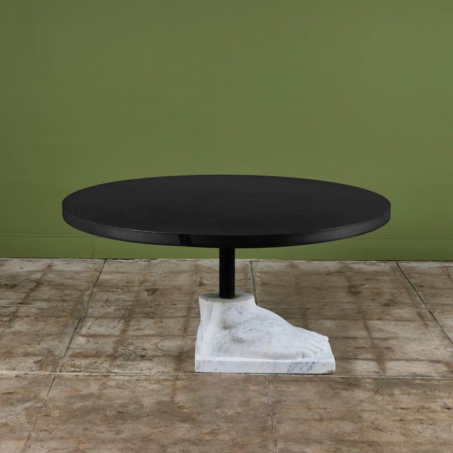 Round postmodern blackened steel dining table features a marble pedestal foot base. The sculptural foot base is carved...