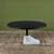 Round postmodern blackened steel dining table features a marble pedestal foot base. The sculptural foot base is carved...