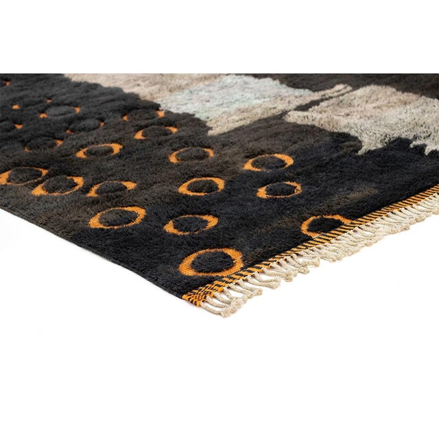 Deep, dramatic, and quietly playful. This hand-knotted Moroccan rug sets a bold visual contrast against a rich charcoal...