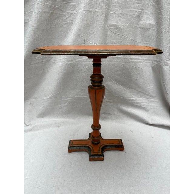 A single vintage wood side or drinks table featuring a rectangle top with cut corners, pedestal base, and orange painted...