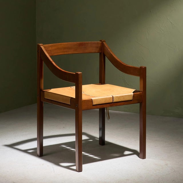 This chair by Jean Gillon features a wooden frame with a finish that highlights the natural grain of the material. The...