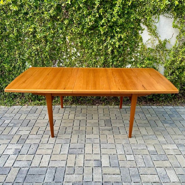 Vintage Scandinavian expandable teak dining table with internal leaf storage, made by Nordic Furniture Company c. 1980s....