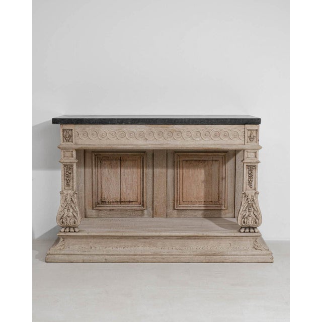 A refined console table featuring a solid oak base paired with a Belgian bluestone top, blending durability with...